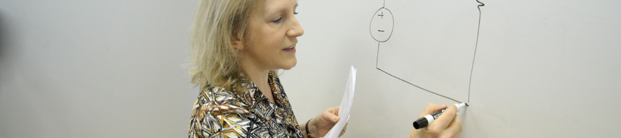 Dr. Russ writes on the board in class.