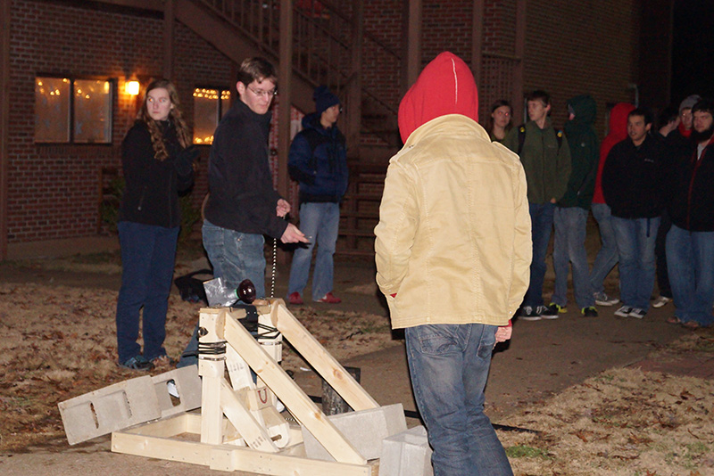 A group of students tests out a water balloon launcher in EGR 101