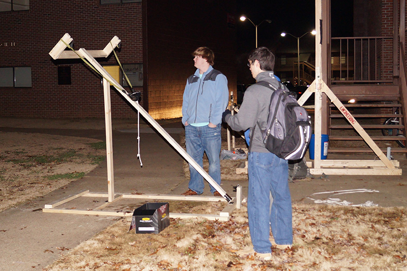 A group of students tests out a water balloon launcher in EGR 101