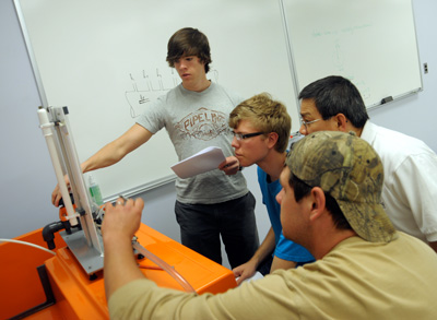 students work with Dr. Van on a lab assignment