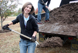 Freshman Laura Axelson shovels mulch at Liberty Garden Park during Campus and Community Day in November. (PHoto by Ebbie Davis)
