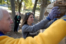 Phi Alpha Theta member Caitlin Roach and group adviser Stephen Carls help build a small log cabin for Green Frog village on Campus and Community Day last November. (Photo by Kristi McMurry)