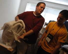 Freshman Jeremy Isbell (right) and his his brother, Kevin, a Union graduate, joke while putting a mattress pad onto Jeremy's new bed in his on-campus apartment. (Photo by Sarah Palmer)