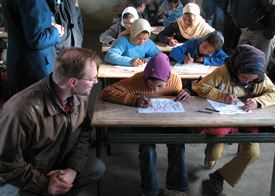 Union engineering professor Randy Schwindt watches as a school girl colors a packet about renewable energy.