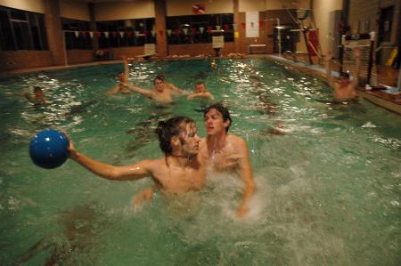 Justin Holder, coach of one of the water polo teams, resists an opponent while leaning back to shoot the ball during the water polo championship held by the Wellness Center.