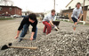 3/25/03 - Casey Stafford, Lance Parrott and Chad Farneth spread gravel on the parking lot at University Baptist Church during GO Illinois.