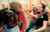 3/24/03 - Freshman Lezli-O'Neal Sullivan, Spanish major, holds one of the day care children at the Salvation Army's Perdue Center of Hope during GO Memphis.