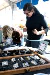 Rose Rogers, senior art major, takes orders for her handmade rings and other jewelry at Arts in the Park. - Photo by Kristi McMurry