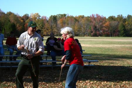 History professor Judy LeForge shares a laugh with Pinson Mounds park ranger Wesley Williams as she tries out atlatl spear-throwing during an afternoon learning session.  
