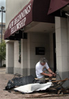 5/5/03 - Union theatre professor and New Beginnings Fellowship elder David Burke tries to work loose a chainlink gate which was hurled into the church's exterior wall by the winds of the tornado.