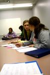 Students participating in the Language capstone group look over each other's papers. - Photo by Kristi McMurry