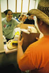Erin Hetzel packs bagged sandwiches in a box for students to pass out to the tornado victims in East Jackson.
 - Photo by Lindsay Stavish