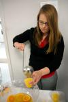 Paige Ward, junior art major, pours punch at the annual student art show reception.  - Photo by Kristi McMurry