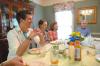 J. Landham, freshman, Hannah Williams, sophomore athletic training major, and Rebecca Eaton, sophomore mathematics major, laugh over a home-cooked meal at the home of Bill and Alice Nettles as part of Be Our Guest. - Photo by Kristi McMurry