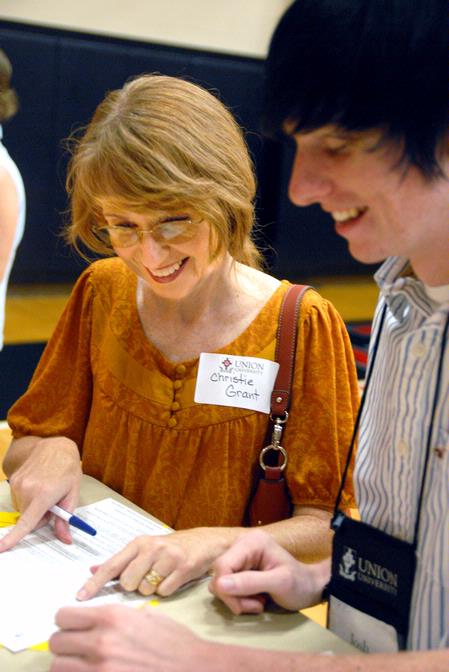 Joshua Grant, freshman, and his mother Christie fill out papers on move-in day.