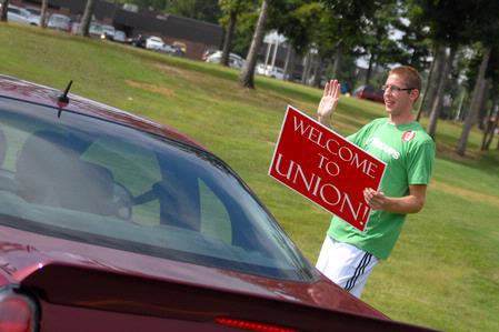 Luke Allison, sophomore mathematics major, directs incoming freshmen into Union on freshman move-in day.