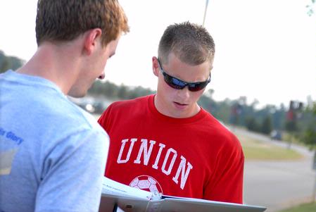 Blake Pennington, intramural director, signs Andrew Griffith, senior business administration major, in to play the football toss competition. 