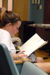Terilyn Wassell, sophomore art major, reads over the JUST sculpture tour program before the reception event begins.  - Photo by Kristi McMurry