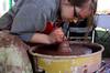 Paige Ward, senior art major, creates pottery during Arts in the Park during Homecoming 2009. - Photo by Megan Bailey