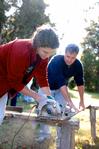 Megan Winters, sophomore history major, cuts a piece of wood as David Thomas, professor of history, holds the board down. The wood is used as part of a building project completed by the history department for Campus and Community Day.  - Photo by Kristi McMurry