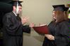 12/12/09 - Wagner Oliveira, DMS-Art graduate, and Amanda Middleton, Art graduate, practice shaking hands with President Dockery before Union's fall graduation ceremony begins. - Beth Spain