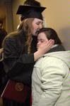 Emily Babin Campbell gives her sister, Elizabeth Babin, a kiss after graduating with a bachelor of science in special education at fall graduation.  - Photo by Kristi McMurry