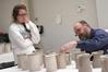 Lee Benson, professor of art and department chair, critiques Kelsey Nagy's canisters for Ceramics IV.  - Photo by Kristi McMurry