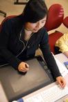 Shinae Giffin, sophomore art major, works on a poster in the digital media studies lab. - Photo by Kristi McMurry