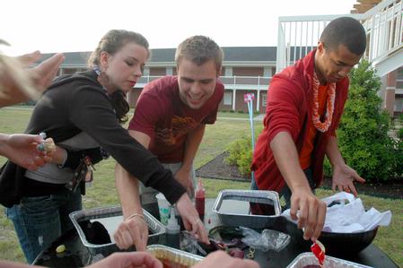 Lauren Richie, Jordan Float and Jordan Timbs dye head bands outside the Bowld Commons during the Residence Life Luau.