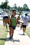 Megan Thompson, junior advertising major, carries chairs and a guitar to a new student's room on Move In Day. - Photo by Deanna Santangelo