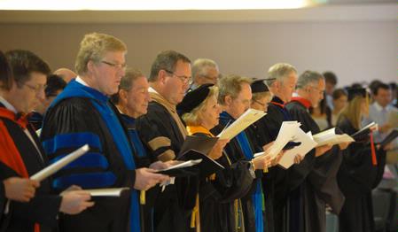 Faculty members, dressed in their academic regalia, sing during the Fall Convocation address. 