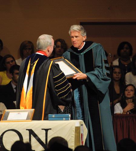 President David S. Dockery presents Richard Wells, vice president for church relations, with a plaque in honor of his new role at the university. 