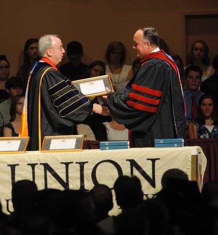 President David S. Dockery presents Jerry Tidwell, senior vice president for university relations, with a plaque in honor of his new role at the university. 