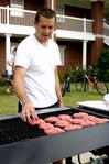 Mark Ellison, senior business administration major, cooks hamburgers at the Watters Great Outdoors event sponsored by Residence Life.  - Photo by Deanna Santangelo