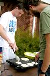 Sam Dahl, senior Christian ethics major, and Zac Settle, junior philosophy major, cook the pancakes that will later be used for the pancake eating contest during the Watters Great Outdoors event. - Photo by Deanna Santangelo
