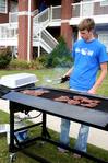 Michael Lewis, junior biology major, cooks the steaks that are rewarded to the top teams during the Watters Great Outdoors competition. - Photo by Deanna Santangelo