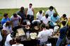 The men of the Watters quad gather around a table to cheer on their teammates who are competing in the pancake eating contest at the Watters Great Outdoors competition. - Photo by Deanna Santangelo