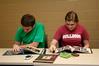 Wil Story, sophomore public relations major, and Amelia Krauss, junior journalism major, look through photo albums of Angel, Fonsi and Lesley Guilaran's adopted child.  - Photo by Deanna Santangelo