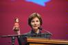 10/19/10 - Laura Bush, former first lady of the United States, holds up a bobble head doll of herself while telling a funny story at the 13th annual Scholarship Banquet. 