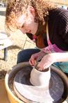 Rachel Moore, junior art major, throws a cup on the wheel at Arts in the Park, a homecoming event.  - Photo by Ebbie Davis