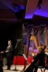 Anna Wicker, senior music major, plays the harp while Chris Mathews, associate professor of music and department chair, directs at this year's A Union Christmas program. - Photo by Deanna Santangelo