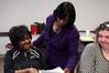 Rhonda Hudson, associate professor of social work and director of BSW adult studies program, hands back papers to students before class. - Photo by Kristi McMurry
