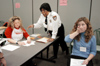 Sophomores Annie Ross, social work major, Kathleen Lokey, Christian studies major, and Bernice Bradford, security officer, play their assigned roles of a family in a poverty simulation sponsored by the Social Work Department. - Photo by Justin Veneman