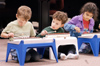 A child looks on as a classmate taps away on his miniature xylophone, one of the many instruments kids learn to play in the Community Music Center's Kindermusik. - Photo by Justin Veneman