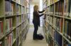 Kayleigh Hines, senior English and music double major, chooses books for research in the Emma Waters Summar Library. - Photo by Abigail Harris