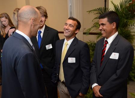Tony Dungy, Super Bowl winning coach, greets Luke Foshee, junior biology major, at the meet and greet part of the Roy L. White Golf and Gala. 