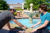 Chris Hayes, senior engineering major, and James Avery, junior engineering major, observe the temperature change of the water while using a solar panel to heat the fountain. - Photo by Ebbie Davis