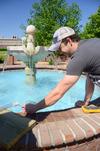 For an engineering experiment, Chris Hayes, senior engineering major, observes the temperature change of the water while using a solar panel to heat the fountain. - Photo by Ebbie Davis