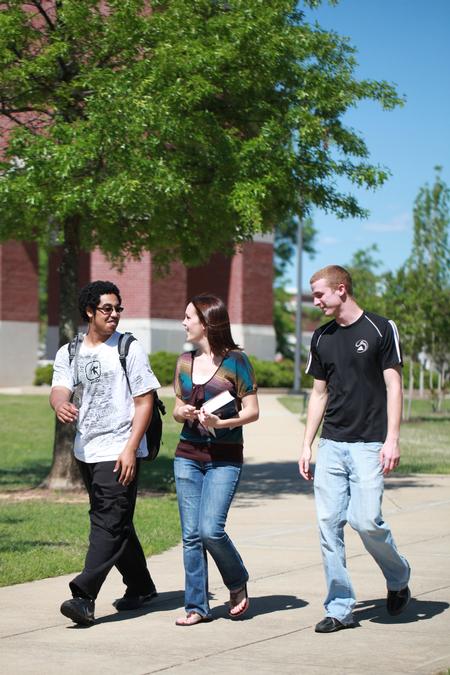 Students walk across campus on a nice, sunny day. 