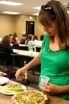 Mary Alisa Techentin, senior history major, tries a homemade salad dressing at Food For Thought, hosted by Joelle Williams. - Photo by Deanna Santangelo